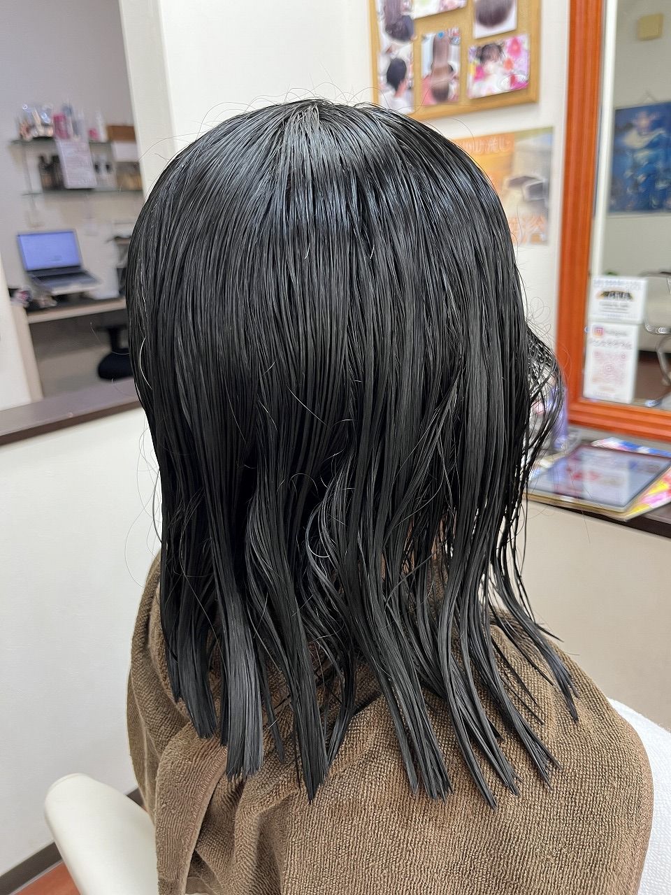 縮毛矯正施術前の後ろ姿。強いクセが見られる濡れた髪の状態。