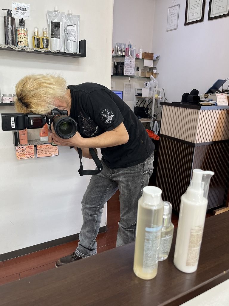 一眼レフで店内商品のPOP用写真を撮影している様子