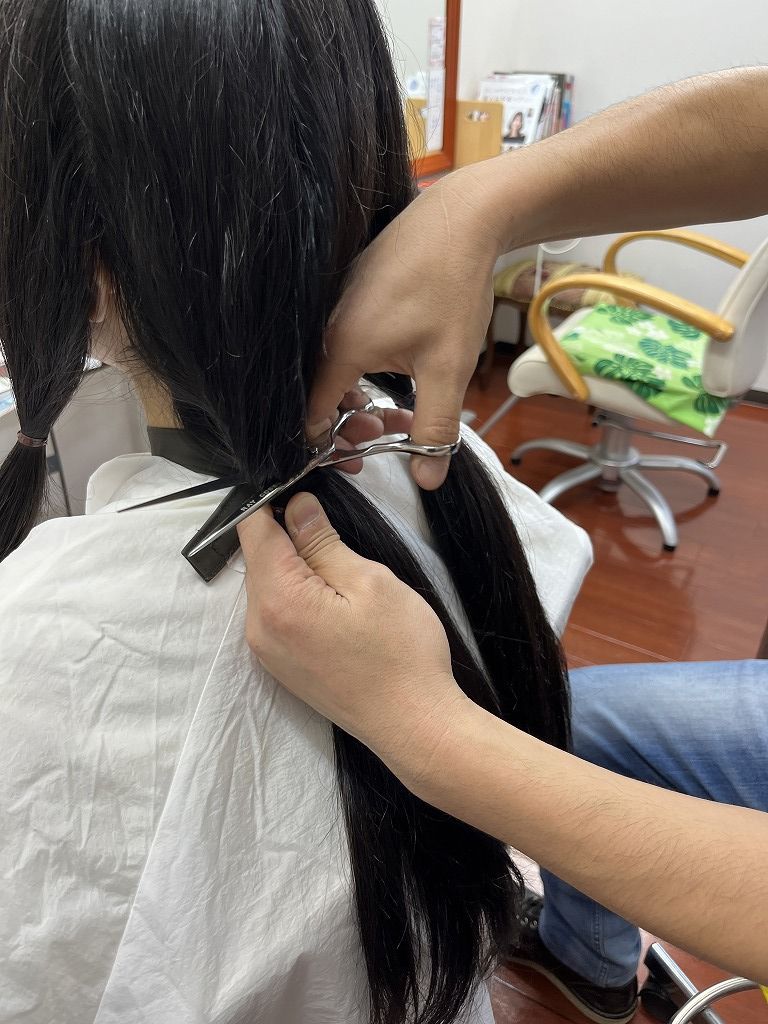 ヘアドネーションの毛束をカットする瞬間