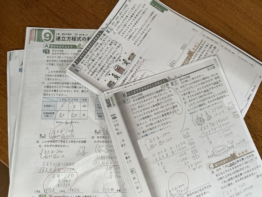数学のプリントを重ねた学習風景の写真