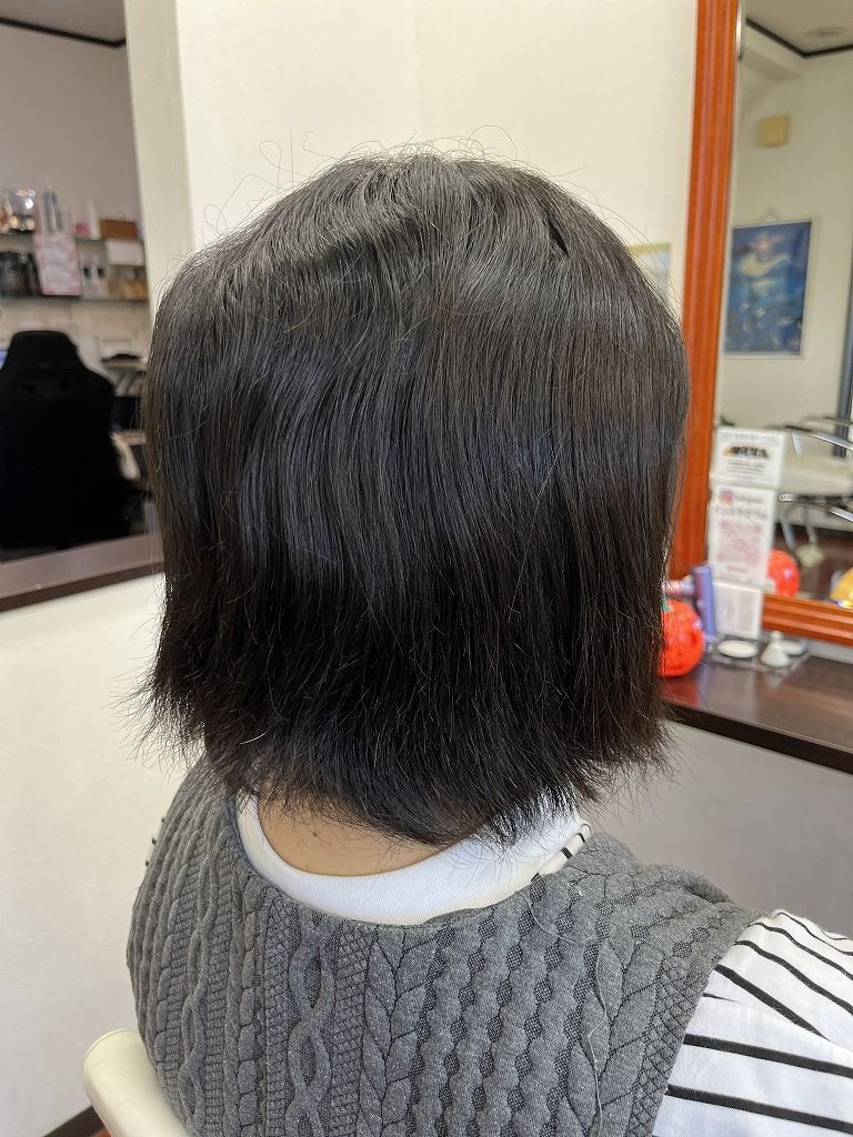 ビフォー:後ろ姿。細く柔らかい髪に強い波状のうねりが出ている状態