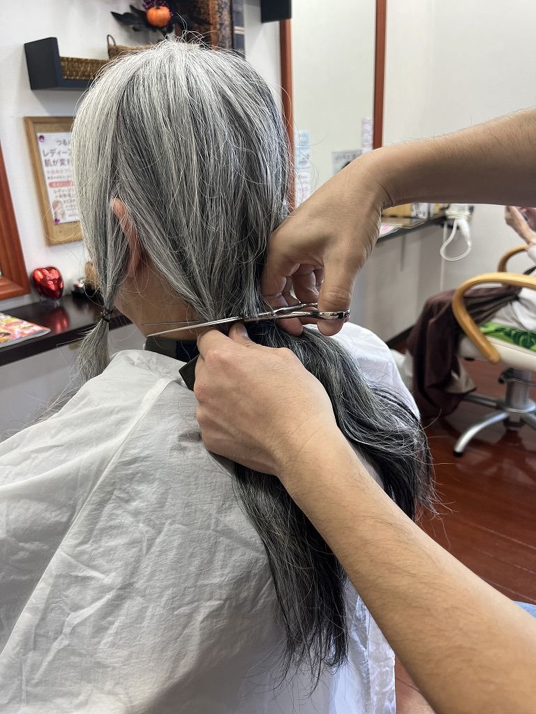 ヘアドネーションの毛束をカットしている様子