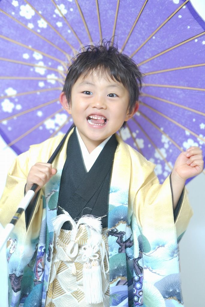七五三の男の子が和傘を持って笑っている写真