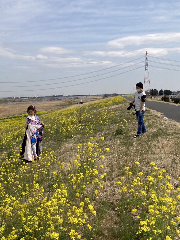 河川敷で袴姿のモデルを撮影している様子