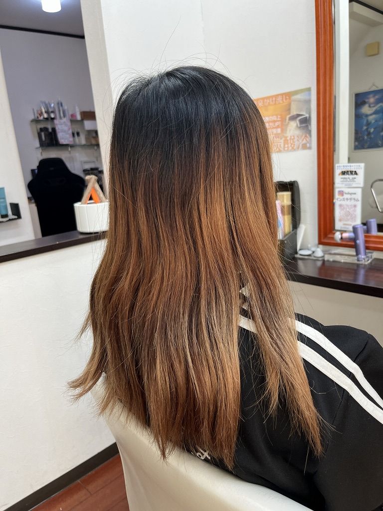 ブリーチ履歴があり、毛先のダメージと色抜けが気になるロングヘアのビフォー写真（斜め後ろ）
