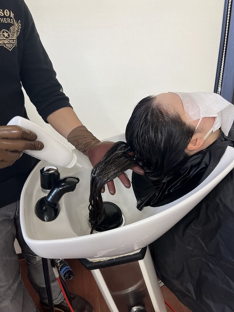 髪質改善トリートメントを髪全体に塗布している様子