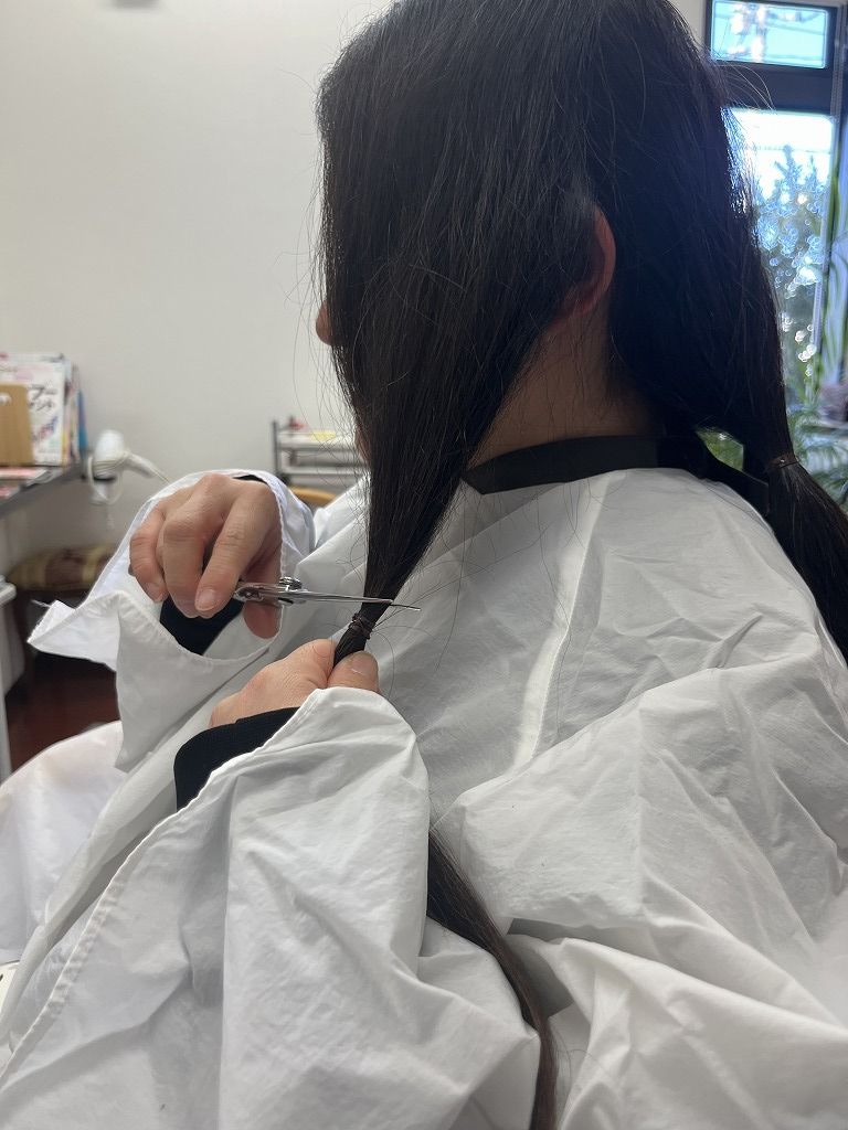 ご自身でヘアドネーションのカットをしている写真