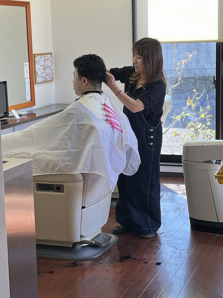 アユがメンズカットを施術している様子。理容の技術で身だしなみを整える