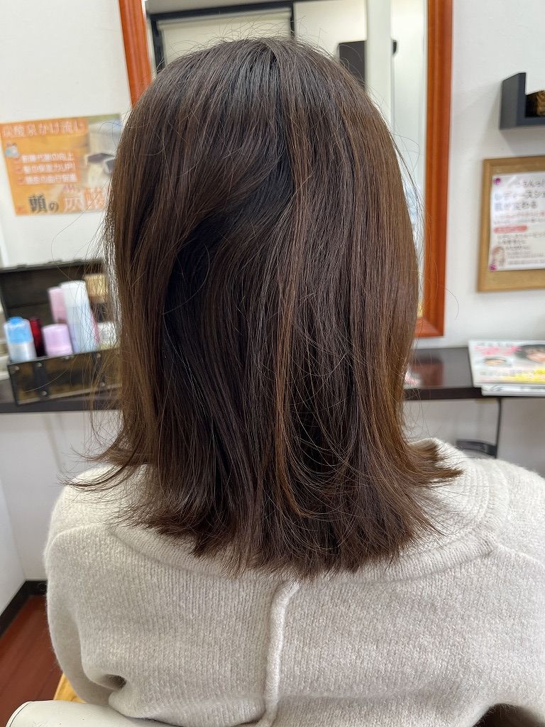 縮毛矯正のビフォー:広がりと毛先のまとまりにくさが出ている後ろ姿