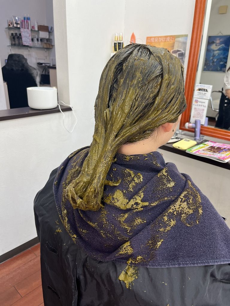 ハナヘナを全体にしっかり塗布した写真。ロングヘア全体にムラなく塗っている状態。