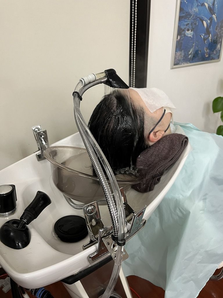 炭酸頭浸浴で頭皮と髪を包み込むように流している様子