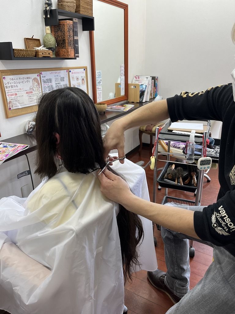 ヘアドネーションで後ろの髪を一気にカットしている様子