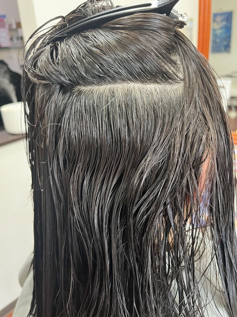 髪をめくって濡れた状態の内側のクセを確認している写真