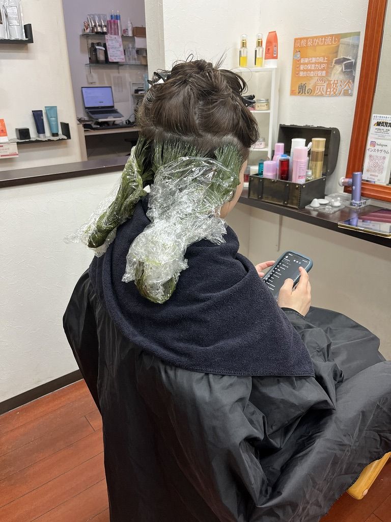 耳後ろから耳上にかけてインナーカラー部分をブリーチしている施術中の写真