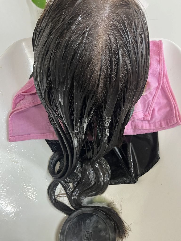 カラー後に髪質改善トリートメントを塗布している写真