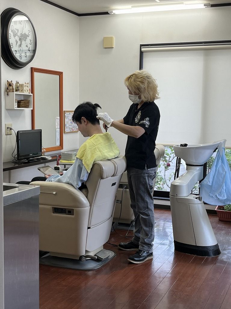 メンズ縮毛矯正の施術中。クセを見ながら丁寧にアイロン施術をしている様子