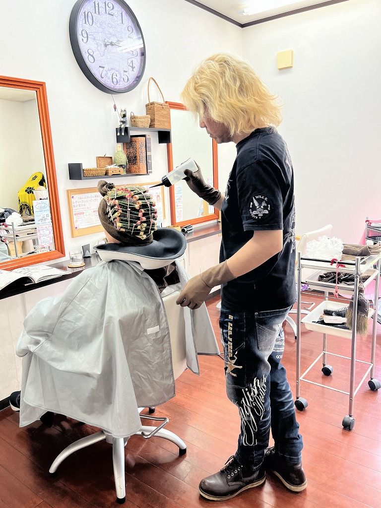 パーマカラー施術中に薬剤を塗布している写真