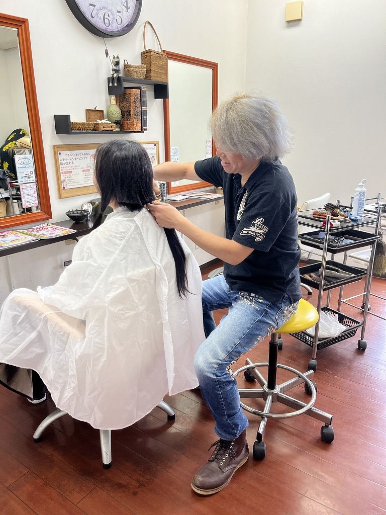 ヘアドネーション用に髪を束ねてカットしている様子