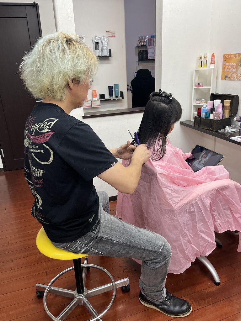 小学校1年生の女の子が1人で座ってカットしている様子