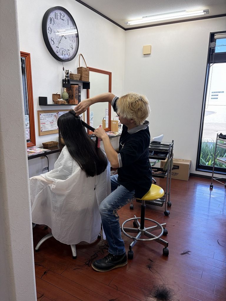 ロングヘアの内側をフレンチカットグランで毛量調節して整える施術風景