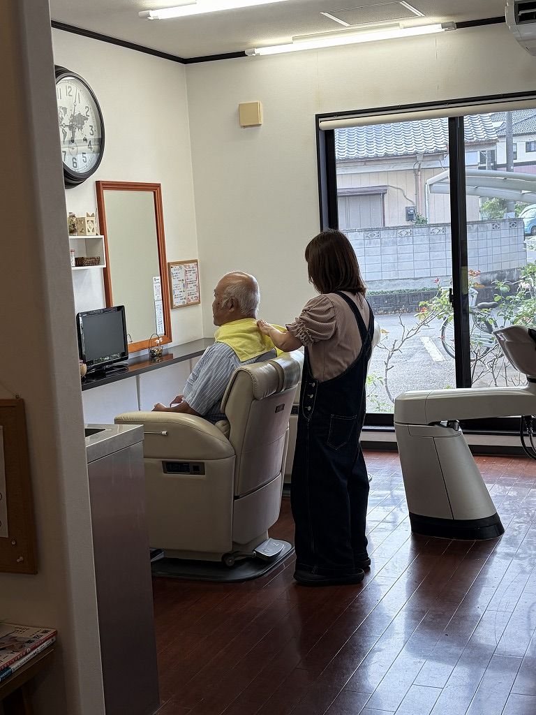 HairResort Arakの店内で男性のお客様の施術を始める理容師の妻