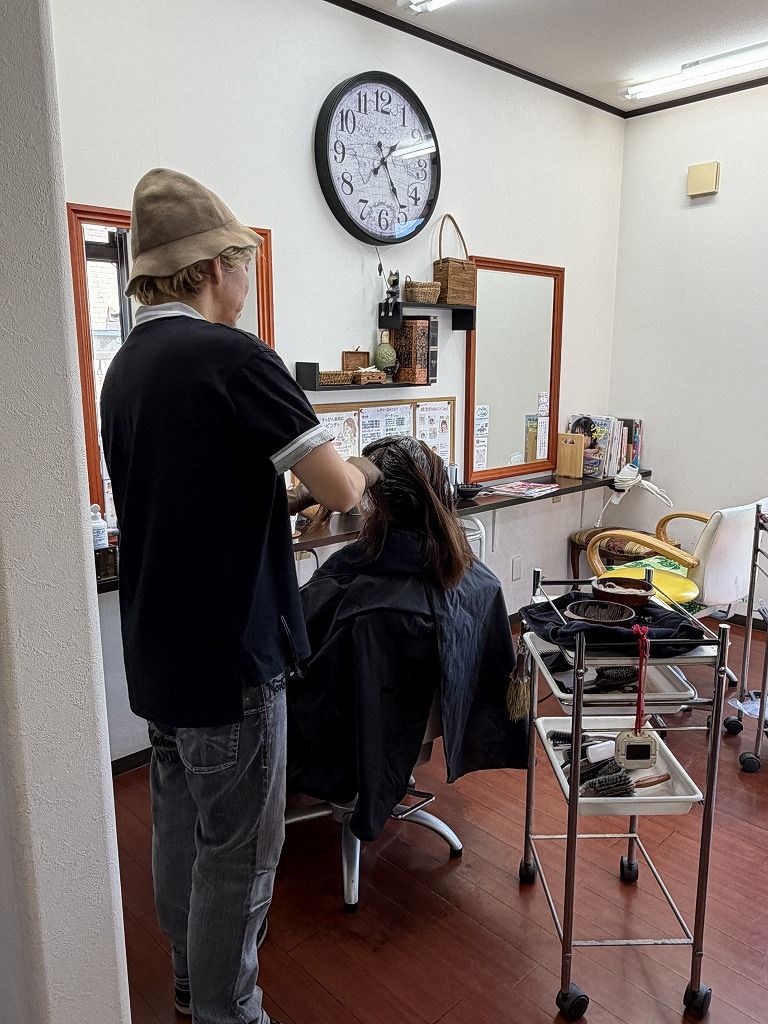 HairResort Arakで女性のお客様へカラー剤を塗布している美容師タイシ