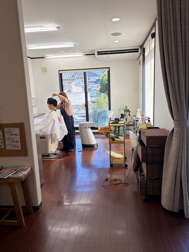 自然光が入るHairResort Arakの店内で男性のお客様をカットする理容師