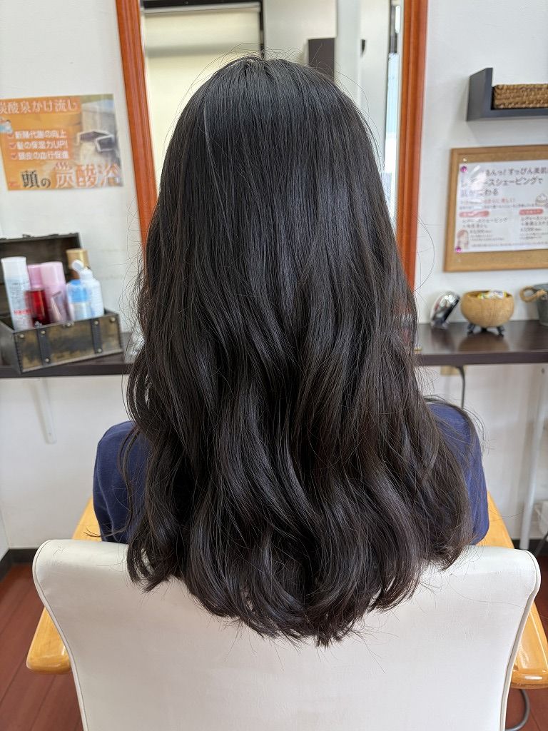 低めのレイヤーとコテ巻きで柔らかな動きを出したロングヘアの仕上がりの後ろ姿