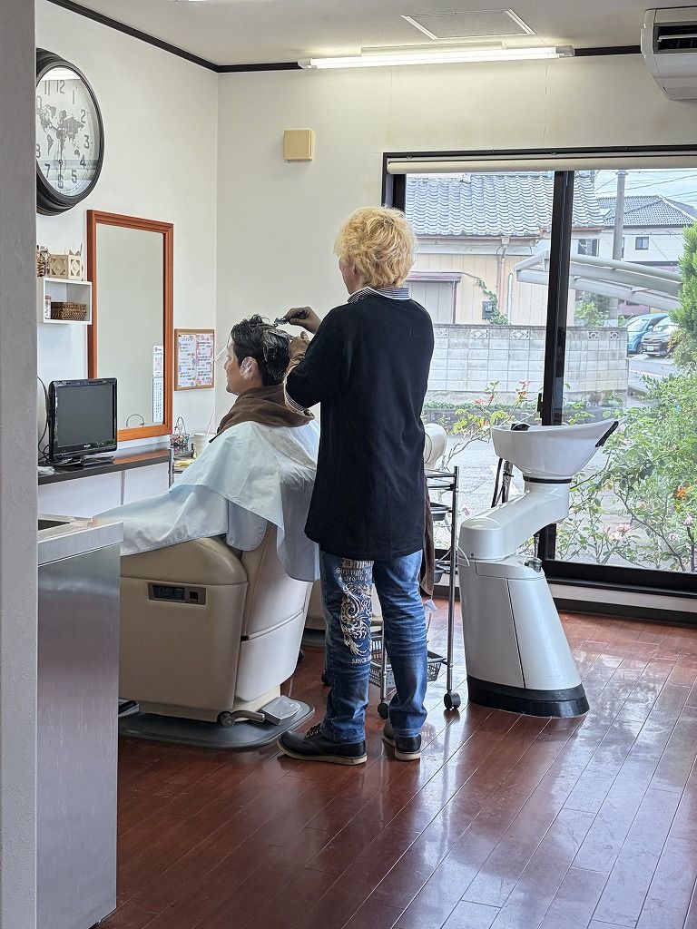 メンズショートの施術中。刈り上げとのつながりや自然な丸みを意識して縮毛矯正を行っている様子