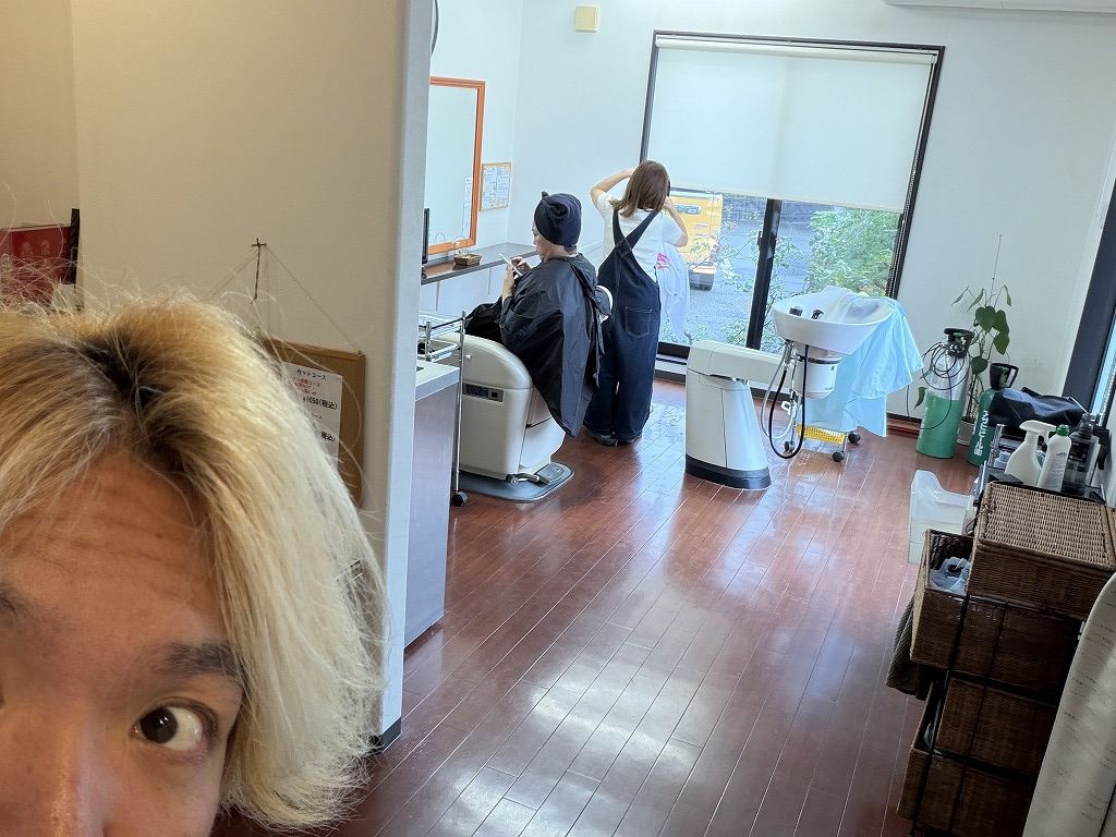 土曜日のHairResort Arak店内で理容施術をする妻アユと手前に写る美容師の大志