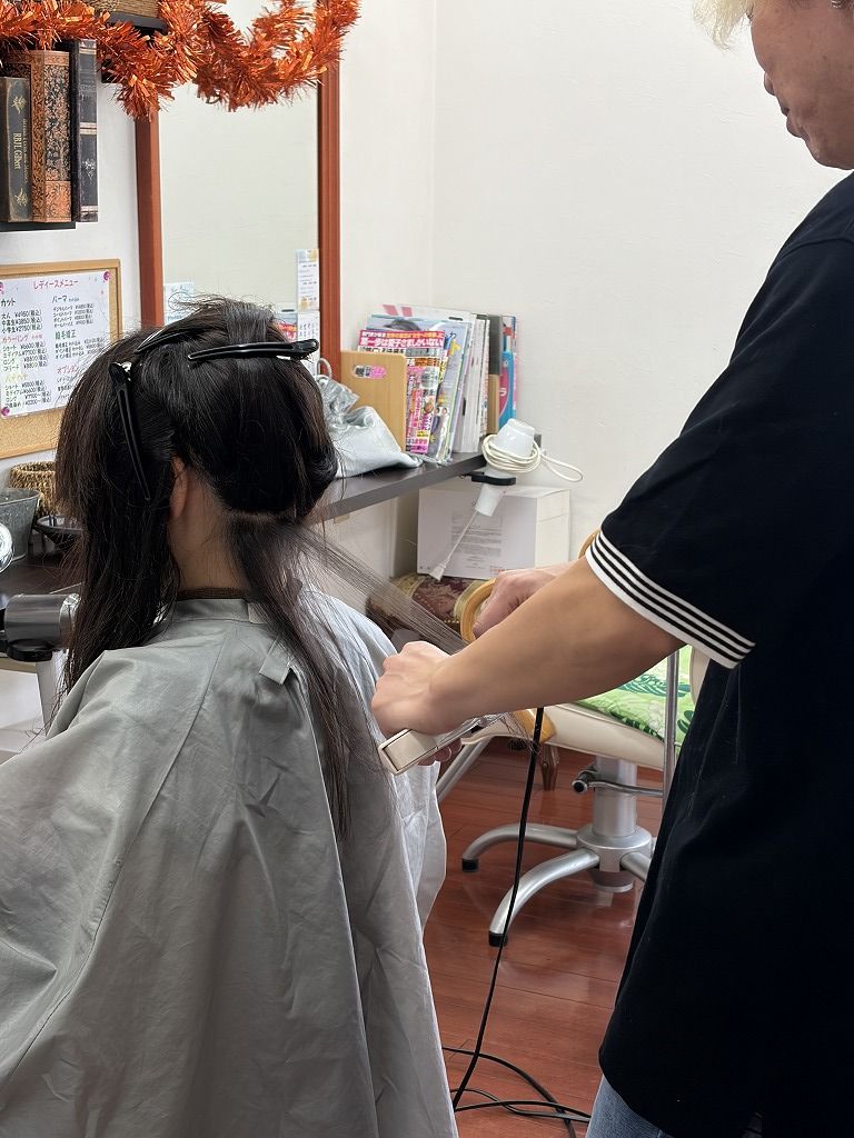 縮毛矯正で毛束ごとにアイロン施術をしている様子