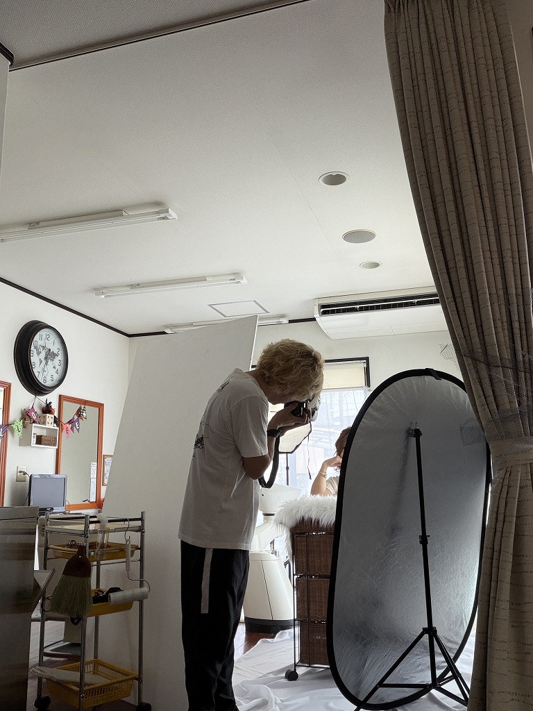 HairResort Arak店内でレフ板を使いサロンモデルを撮影している様子