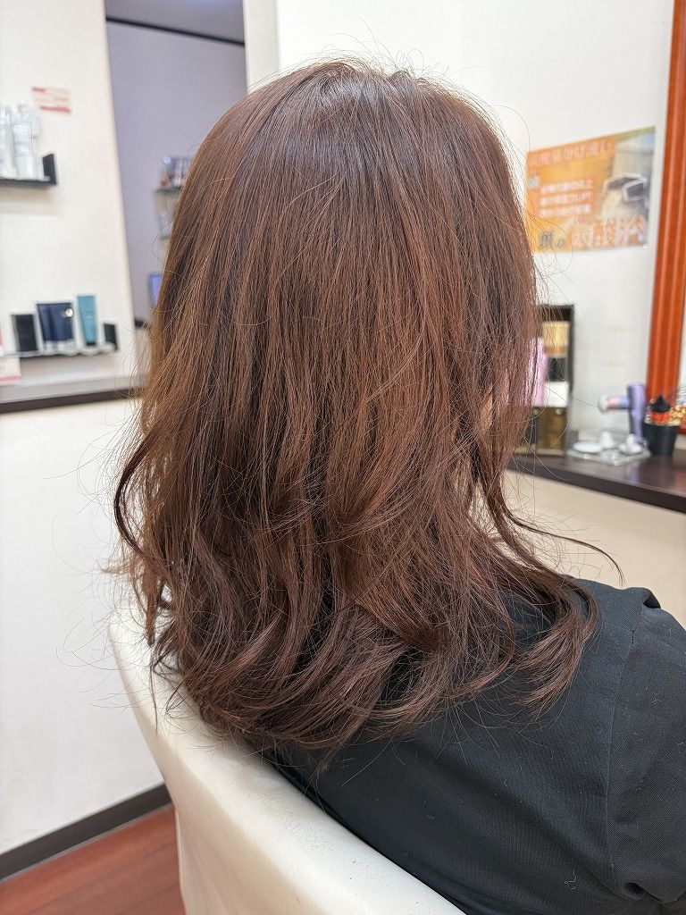 9レベルのオレンジベージュで明るく白髪染めしたミディアムヘアの仕上がり。デジタルパーマのカールを生かしたスタイル